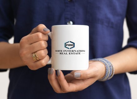 A New Jersey real estate agent holding a Fourte International Real Estate coffee mug