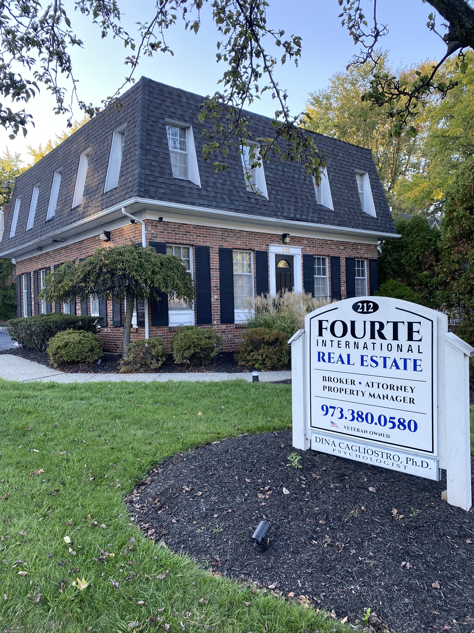 Fourte International Real Estate's Headquarters building in Essex County New Jersey with a sign on the front lawn advertising broker, attorney and property manager services